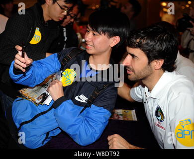 Spanish soccer star Raul Gonzalez Blanco of New York Cosmos, right, takes a selfie with a fan at a signing event in Hong Kong, China, 16 February 2015 Stock Photo