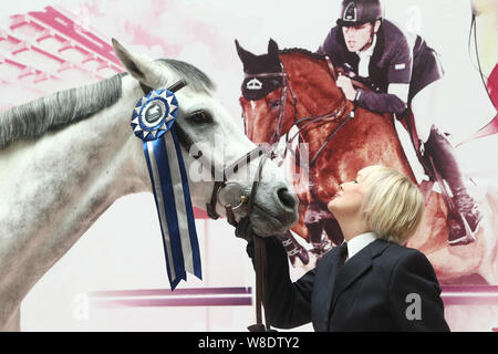 British etiquette expert Diana Mather kisses a horse at an equestrian exhibition at CITIC Pacific Plaza ahead of the 2015 Shanghai Longines Global Cha Stock Photo