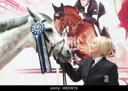 British etiquette expert Diana Mather poses with a horse at an equestrian exhibition at CITIC Pacific Plaza ahead of the 2015 Shanghai Longines Global Stock Photo