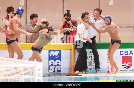 Coaches and players of Japan men's national water polo team celebrate after defeating China men's national water polo team during the 2015 Asian Water Stock Photo