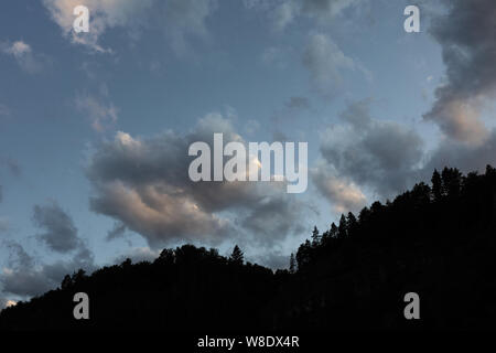 Overcast sky before rain in the mountains. dark cloudy sky.  clouds come up from the tops of the mountains Stock Photo