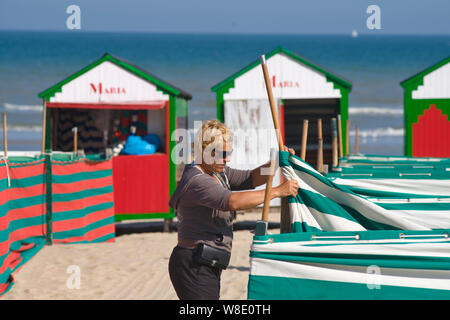 colorful and vintage beach cabins resting all summer on the sand of the beach in De Panne, Belgium Stock Photo