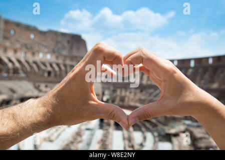 Couple Making Heart Shape In Inside Of Colosseum, Italy Stock Photo