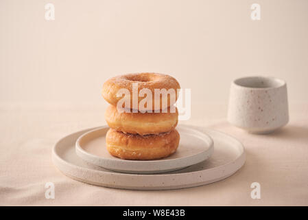 Stack of homemade baked donuts sitting on white plate Stock Photo