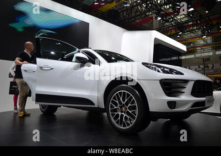 --FILE--Visitors look at a Porsche Macan S during an auto show in Wenling city, east Chinas Zhejiang province, 30 April 2014.     Newly minted Chinese Stock Photo