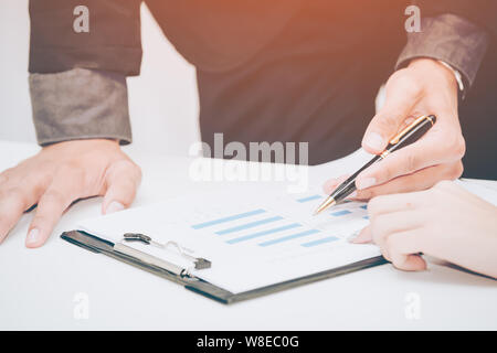 two business discussing the scheme and pointing handles on the chart Stock Photo