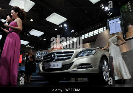 --FILE--Models pose with a Mercedes-Benz CLS-Class car during an automobile exhibition in Guiyang city, southwest China's Guizhou province, 12 April 2 Stock Photo