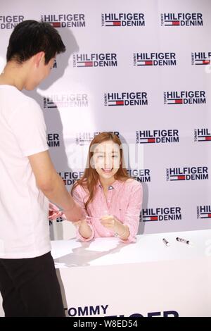 Singer and actress Goo Ha-ra, right, also known as Koo Ha-ra, of South Korean girl group Kara, sticks out her tongue as she hands over her signature t Stock Photo