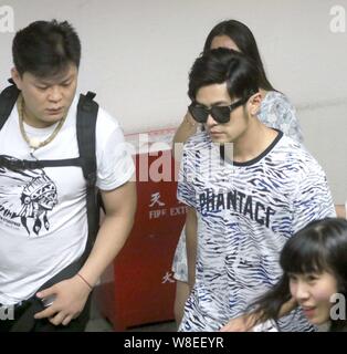 Taiwanese singer Jay Chou, right, is pictured after arriving at the Shanghai Hongqiao International Airport in Shanghai, China, 29 June 2015. Stock Photo