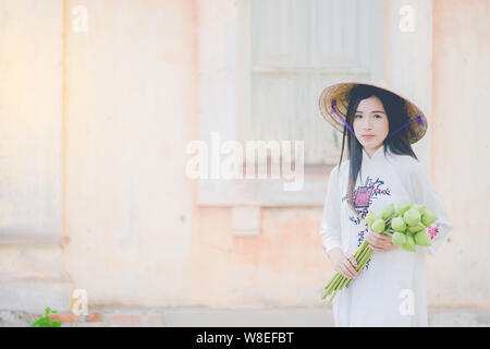 beautiful woman with Vietnam culture tranditional dress, Ao dai and  holding lotus Stock Photo