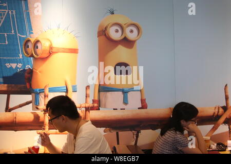 Customers eat at a Minions-themed McDonald's fastfood restaurant in Shanghai, China, 2 July 2015.   The Minions from Universal Pictures and Illuminati Stock Photo