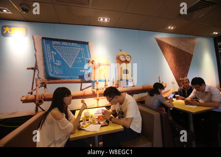 Customers eat at a Minions-themed McDonald's fastfood restaurant in Shanghai, China, 2 July 2015.   The Minions from Universal Pictures and Illuminati Stock Photo