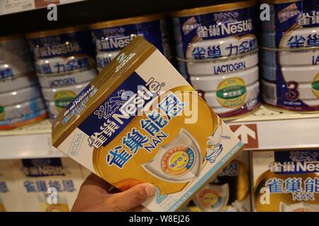 --FILE--A customer shops for a carton of Nestle infant formula at a supermarket in Xuchang city, central China's Henan province, 8 June 2014.   Nestle Stock Photo