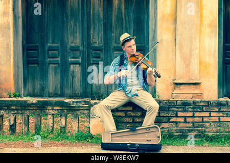 caucasian man playing violin with old house colonial style background Stock Photo