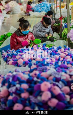 --FILE--Female Chinese workers sew stuffed toys to be exported to Europe and the United States markets at a garment factory in Ganyu Economic Developm Stock Photo