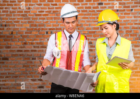woman and man working with old brick wall background at construction site,engineering concept Stock Photo