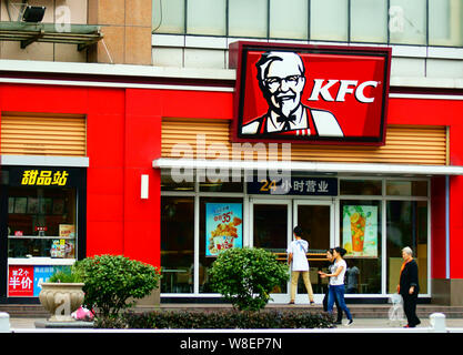 --FILE--Pedestrians walk past a KFC fastfood restaurant of Yum Brands in Yichang city, central China's Hubei province, 30 September 2015.   Shares of Stock Photo