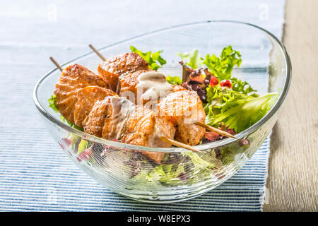 Grilled salmon skewers with summer lettuce salat pomehranate seeds olive oil and dressing. Healthy fish food with fruit and vegetable Stock Photo