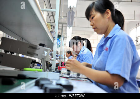 --FILE--Female Chinese workers produce mobile phone parts on the ...