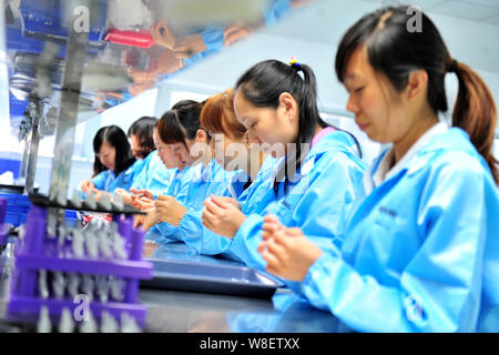 --FILE--Female Chinese workers produce mobile phone parts on the ...