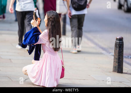 Cambridge, UK, August 1, 2019. Turists walking down and taking pictures at the street of Cambridge on a busy sunny day in front of Kings College Stock Photo