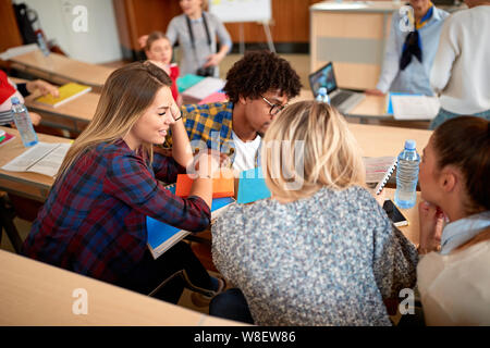 Group of smiling students learning in classroom Stock Photo