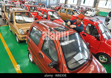 --FILE--A Chinese worker assembles an electric car on the assembly line ...