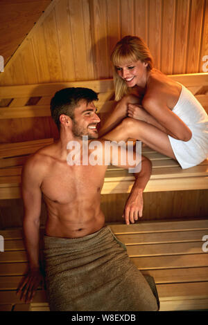 Happy couple detoxing body in sauna Stock Photo