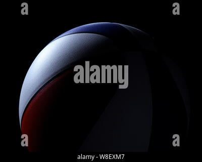 Front view on red white and blue colored single basketball sitting on black background. Light shining directly on basketball. Stock Photo