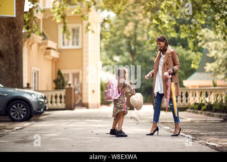 Young parent helping their little child get ready for school Stock Photo