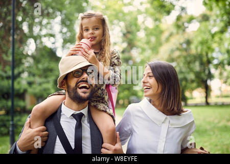 happy family walking together in park after school Stock Photo