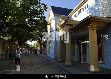 --FILE--Customers walk past a store of Valentino at the Beijing Scitech Premium Outlet Mall in Beijing, China, 7 June 2014.   China has a shopping mal Stock Photo