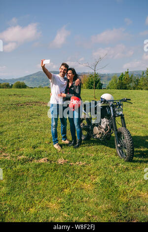 Couple taking a selfie with a motorcycle Stock Photo