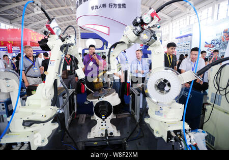 --FILE--Visitors look at robot arms on display during the 14th China International Equipment Manufacturing Exposition in Shenyang city, northeast Chin Stock Photo