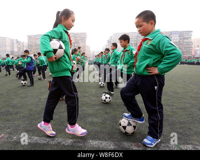 Young Chinese students perform a football exercise at the opening ceremony for the Fourth Campus Football Culture Festival at Yixingbu No.3 Primary Sc Stock Photo