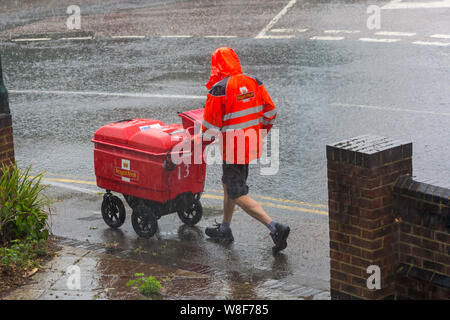 Bournemouth, Dorset UK. 9th Aug 2019. UK weather: the bad weather has arrived as torrential rain falls in Bournemouth. Postman wearing shorts hurries on his rounds regardless of the weather!  Credit: Carolyn Jenkins/Alamy Live News Stock Photo