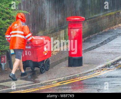 Bournemouth, Dorset UK. 9th Aug 2019. UK weather: the bad weather has arrived as torrential rain falls in Bournemouth. Postman wearing shorts hurries on his rounds regardless of the weather!   Credit: Carolyn Jenkins/Alamy Live News Stock Photo