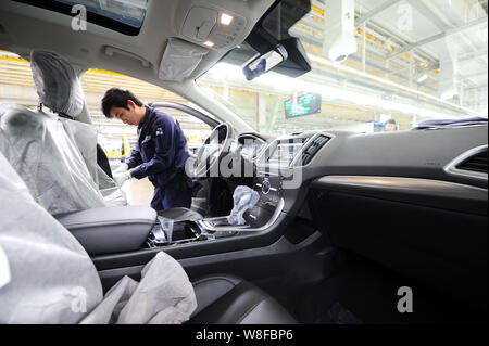 A Chinese worker assembles a Ford SUV on the assembly line at the auto ...