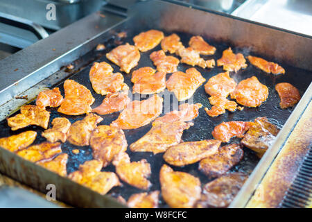 Portioned pieces of chop meat are fried in oil in an open kitchen. Stock Photo