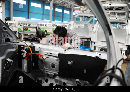--FILE--A Chinese worker assembles an electric car on the assembly line ...