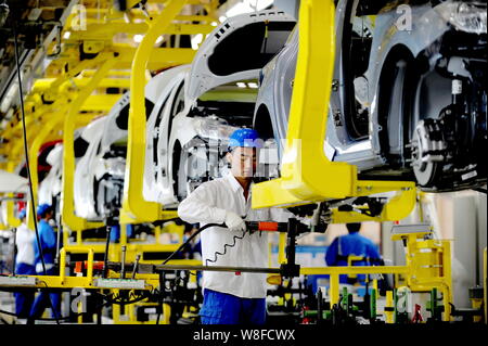 Chinese workers assemble Chevrolet cars on the assembly line at an auto ...