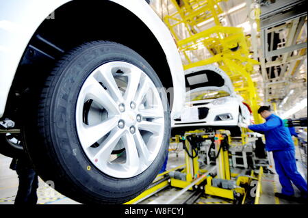 Chinese workers assemble Chevrolet cars on the assembly line at an auto ...
