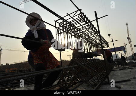 --FILE--Chinese migrant workers labor at the construction site of a residential property project in Rizhao city, east China's Shandong province, 3 Nov Stock Photo