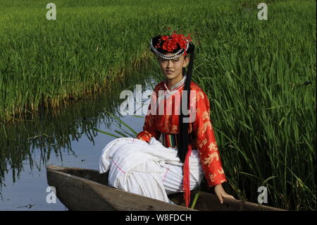 --FILE--A young Chinese woman of Mosuo ethnic group is pictured at the bank of Lugu Lake in Lijiang, southwest China's Yunnan province, 23 July 2009. Stock Photo