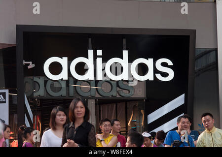 FILE Pedestrians walk past an Adidas Basketball sportswear store