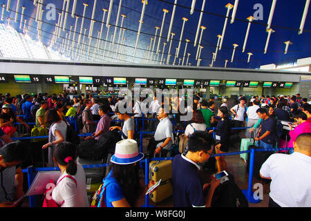 --FILE--A crowd of passengers queue up in front of counters of airlines after their flights were delayed or cancelled due to thunder storms at the Sha Stock Photo