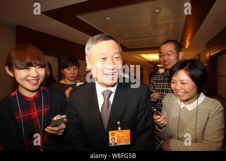 --FILE--Xiao Gang, center, Chairman of the China Securities Regulatory Commission (CSRC), is interviewed as he arrives at a panel discussion during th Stock Photo