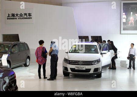 --FILE--Visitors look at or try out a New Tiguan SUV of Shanghai Volkswagen, a joint venture between SAIC Motor and VW, during an auto show in Shangha Stock Photo