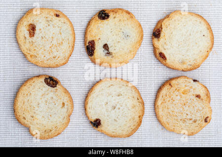 Mini round toasts of bread with raisins. 6 units. On delicate fabric background. Stock Photo