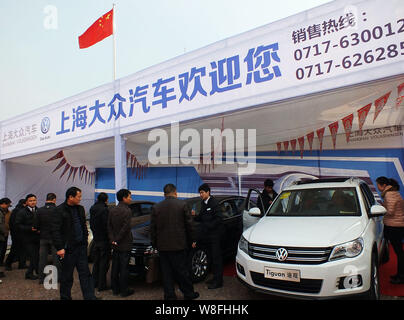 --FILE--Visitors look at or try out a Tiguan of Shanghai Volkswagen, a joint venture between SAIC and VW, during an auto show in Yichang city, central Stock Photo